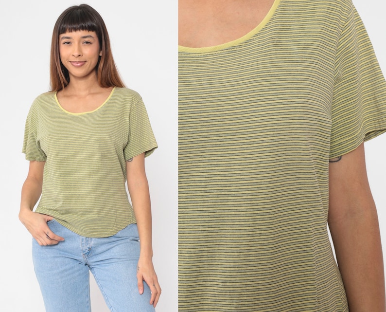 Peut inclure: T-shirt &agrave; manches courtes ray&eacute; vert et gris avec un col jaune. Le t-shirt a une encolure arrondie et une coupe d&eacute;contract&eacute;e. Le tissu semble &ecirc;tre une mati&egrave;re douce et l&eacute;g&egrave;re.