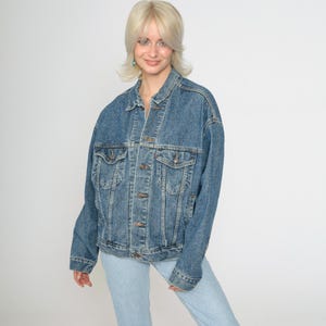 May include: A blue denim jacket with a classic button-up front and long sleeves. The jacket has a relaxed fit and is made of a soft, comfortable denim.