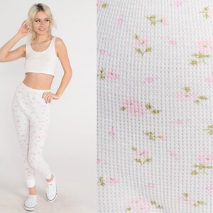 May include: White thermal leggings with a small pink floral pattern.