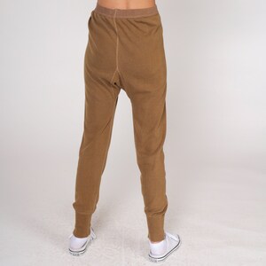 Op de afbeelding: Een broek van bruine thermische onderkleding. De broek is gemaakt van een zachte, comfortabele stof en heeft een ontspannen pasvorm.