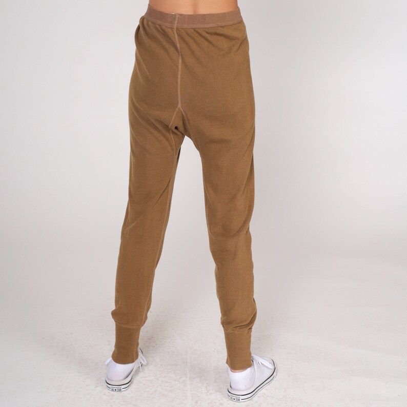 Op de afbeelding: Een broek van bruine thermische onderkleding. De broek is gemaakt van een zachte, comfortabele stof en heeft een ontspannen pasvorm.