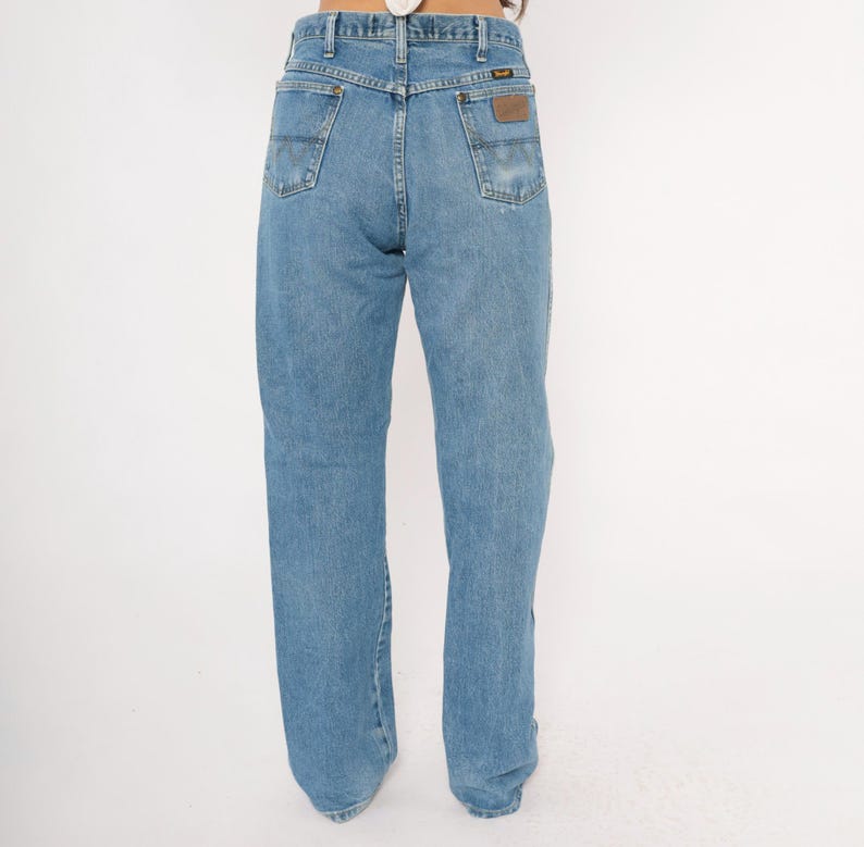 Pu&ograve; includere: Jeans in denim blu chiaro con un classico design a cinque tasche. I jeans hanno un taglio dritto e una toppa in pelle marrone sulla tasca posteriore. I jeans sono realizzati in resistente denim.