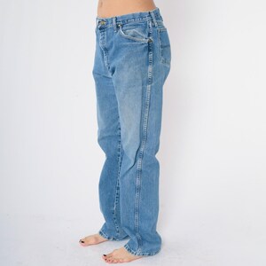Pu&ograve; includere: Un paio di jeans blu chiaro a gamba dritta.