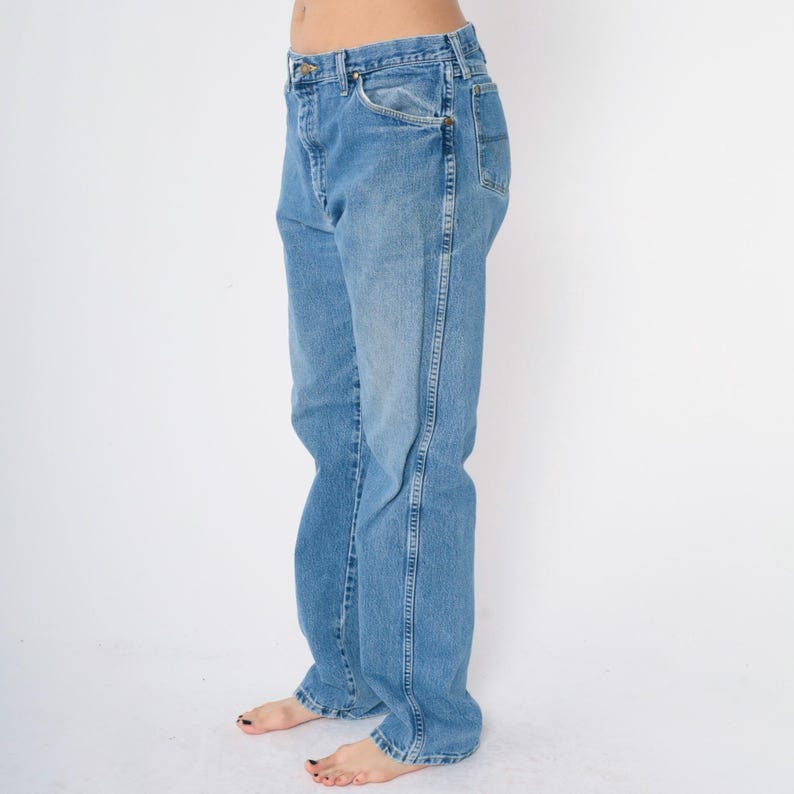 Pu&ograve; includere: Un paio di jeans blu chiaro a gamba dritta.