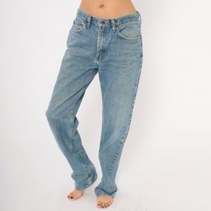 Peut inclure: Jean en denim bleu clair avec une conception classique &agrave; cinq poches. Le jean a une coupe droite et une fermeture &agrave; bouton et fermeture &eacute;clair. Le denim a un d&eacute;lavage d&eacute;color&eacute;, donnant au jean un aspect vintage.