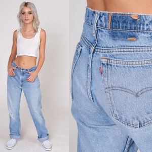 May include: A pair of light blue denim jeans with a high waist and a straight leg. The jeans have a classic five-pocket design and a faded look.