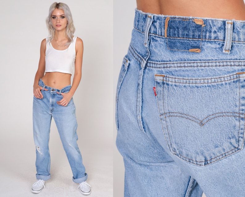 May include: A pair of light blue denim jeans with a high waist and a straight leg. The jeans have a classic five-pocket design and a faded look.