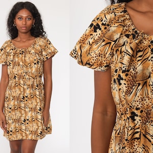 May include: A short-sleeved dress with a scoop neckline and an elastic waist. The dress features a tan, black, and brown animal print pattern. The dress has a loose, flowing skirt and short, ruffled sleeves.
