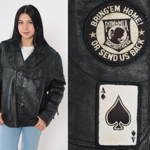 May include: Black leather motorcycle jacket with zipper accents and a patch that reads "Bring 'em Home! POW MIA Or Send Us Back". The jacket also has a patch of an ace of spades.