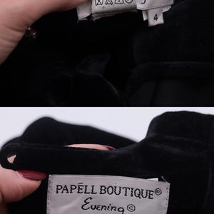 Może przedstawiać: Czarna aksamitna sukienka z białą metką, na kt&oacute;rej widnieje napis "Papell Boutique Evening" oraz "90% Poliester 10% Elastan Czyszczenie wyłącznie chemiczne Wyprodukowano w Chinach". Metka zawiera r&oacute;wnież numer "4".