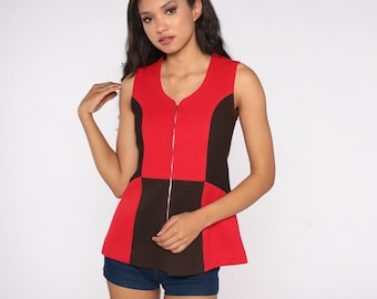 May include: A sleeveless top with a red and brown geometric pattern. The top has a zipper down the front and a slightly flared hem.