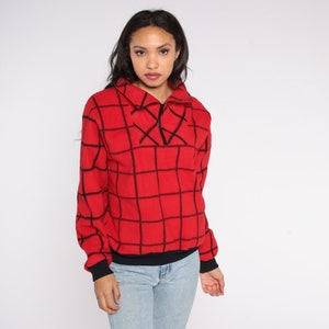 May include: Red and black checkered fleece pullover with a zippered collar.