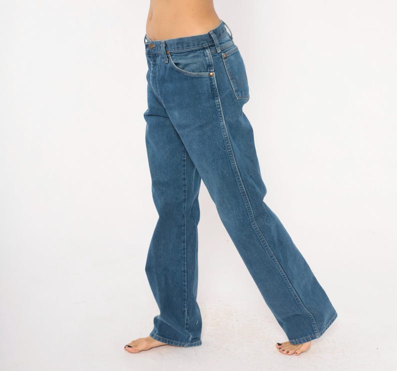 May include: Blue denim jeans with a classic five-pocket design. The jeans have a straight leg cut and a medium wash. The image shows the jeans from the waist down, with a white background.