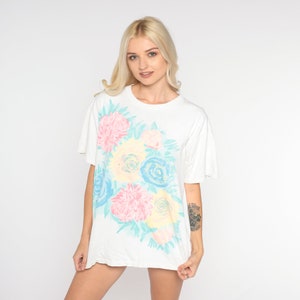 Puede incluir: Camiseta blanca de gran tama&ntilde;o con estampado floral pastel con flores rosas, azules y amarillas.