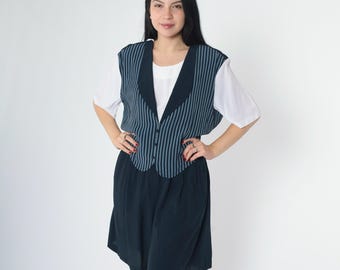 Op de afbeelding: Een mouwloos gestreept vest met knoopsluiting en een bijpassende rok. Het vest heeft een zwarte kraag en er is een wit onderhemd onder zichtbaar.
