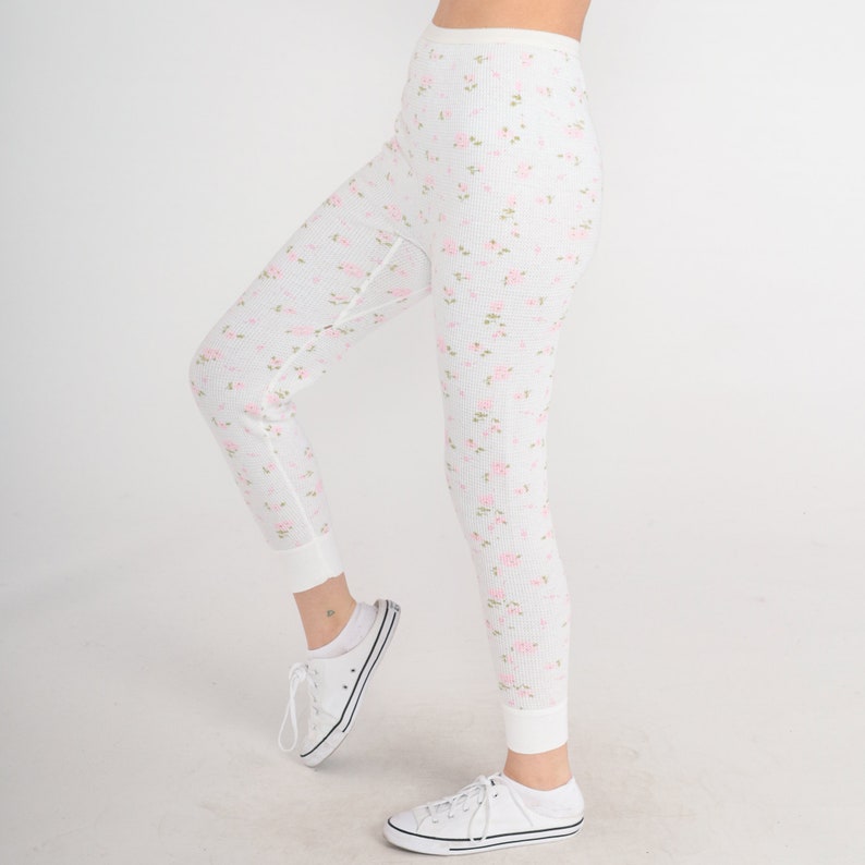 May include: White thermal underwear with a floral print. The underwear has a high waist and a fitted leg.