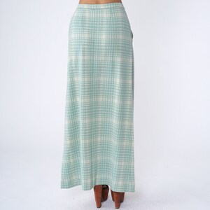 May include: A long, light blue skirt with a white plaid pattern. The skirt has a high waist and a straight silhouette.