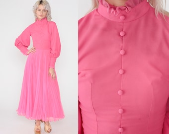 May include: A bright pink vintage dress with a high ruffled collar and long sleeves. The bodice features a row of buttons down the front. The skirt is a flowing, pleated design. The dress is a vibrant, eye-catching piece.