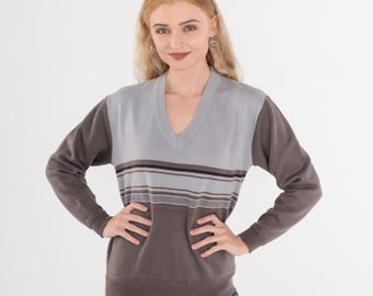 May include: A long-sleeved sweater with a striped pattern in brown, gray, and white. The sweater has a v-neck and is made of a soft, comfortable material.