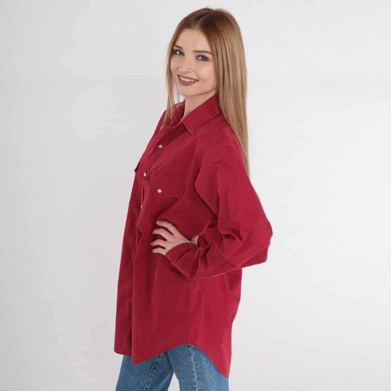 May include: A long-sleeved, burgundy button-down shirt with two chest pockets and a relaxed fit.