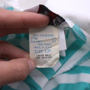 May include: White and turquoise striped shirt with a white tag that reads "100% Polyester", "Style 716-2987", "Lot 329", "Care Over", "Made in USA", "Size 10P", "Union Made See Reverse".