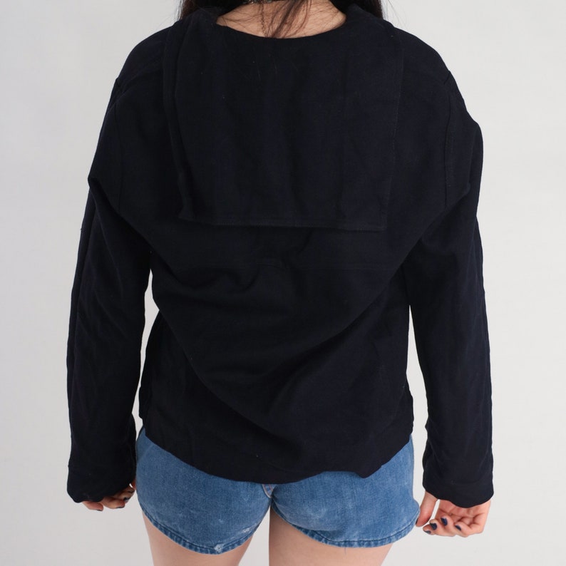 May include: A black long-sleeved shirt with a large, folded collar. The shirt has a relaxed fit and is made of a soft, comfortable fabric.