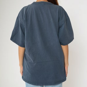 May include: A dark blue, short-sleeved t-shirt with a crew neck.
