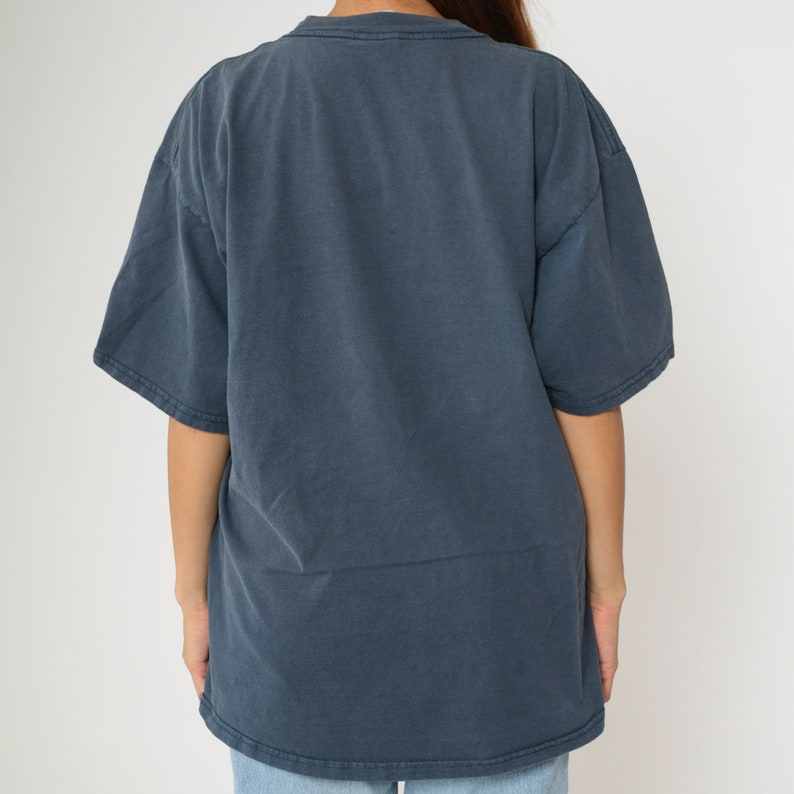 May include: A dark blue, short-sleeved t-shirt with a crew neck.