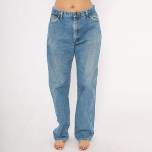 Pu&ograve; includere: Jeans in denim blu chiaro con un classico design a cinque tasche. I jeans hanno una vestibilit&agrave; rilassata e un lavaggio sbiadito, con chiusura con bottone e cerniera. I jeans sono realizzati in resistente materiale denim.