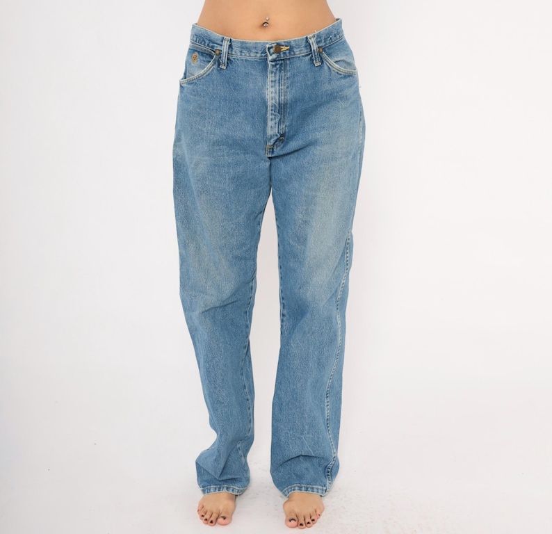 Pu&ograve; includere: Jeans in denim blu chiaro con un classico design a cinque tasche. I jeans hanno una vestibilit&agrave; rilassata e un lavaggio sbiadito, con chiusura con bottone e cerniera. I jeans sono realizzati in resistente materiale denim.