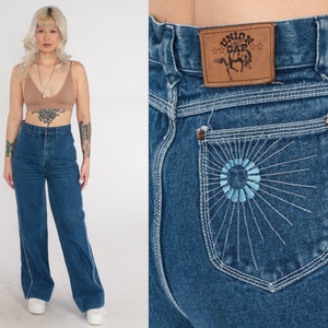 May include: High-waisted blue denim jeans with a wide leg and a