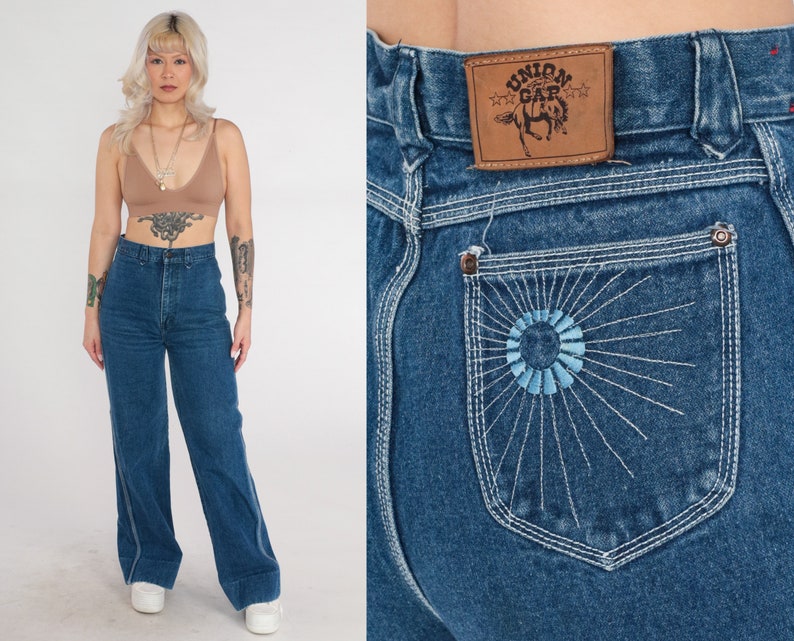 May include: High-waisted blue denim jeans with a wide leg and a