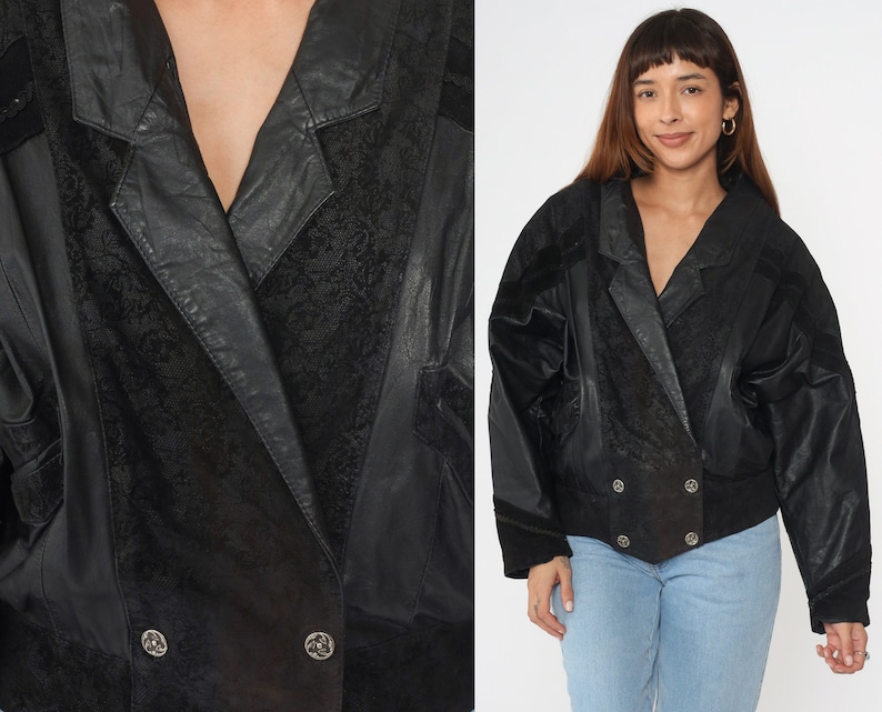 May include: A black leather jacket with a double-breasted closure and a textured pattern. The jacket has a collar and long sleeves.