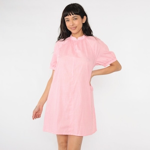 Könnte beinhalten: Ein rosa-weißes Gingham-Kleid mit kurzen Ärmeln und einem Kragen.