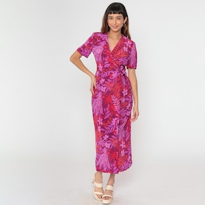 May include: A pink and red floral print wrap dress with short sleeves. The dress has a V-neckline and a tie waist.