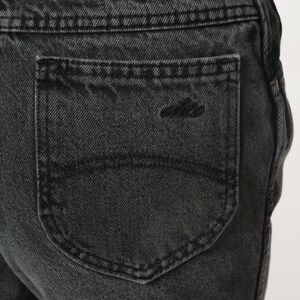 Pode incluir: Close-up de um bolso traseiro de ganga preto com um detalhe de costura &uacute;nico.