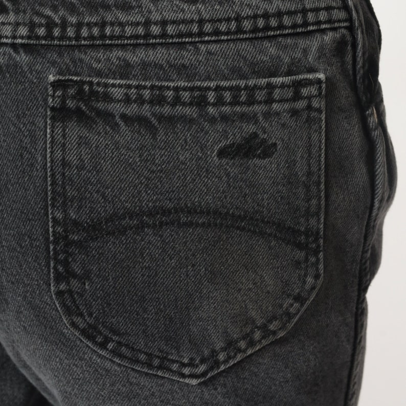 Pode incluir: Close-up de um bolso traseiro de ganga preto com um detalhe de costura &uacute;nico.