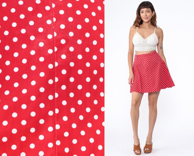 Peut inclure: Une jupe rouge &agrave; pois blancs. La jupe est trap&egrave;ze et a une taille haute.
