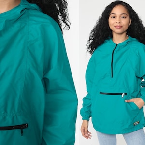 May include: Teal blue hooded jacket with a zipper closure and a large front pocket. The jacket has a drawstring hood and a relaxed fit.