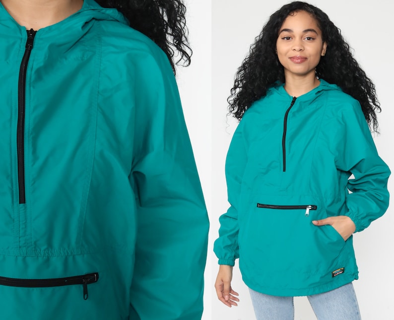 May include: Teal blue hooded jacket with a zipper closure and a large front pocket. The jacket has a drawstring hood and a relaxed fit.
