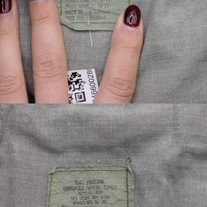May include: A green camouflage fabric label with instructions for washing and care. The label reads "US Woodland Camouflage Pattern, Combat 12175-65-00685 50% Cotton 35% Polyester 15% Nylon, Wash inside out, Adjust closures to ventilate, Machine washing, Use permanent press cycle, Wash in warm water with mild soap, Tumble dry low, Do not wring or twist, Do not use chlorine bleach or starch, Do not remove this label."