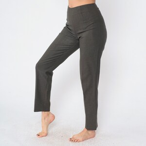 May include: A pair of dark gray high-waisted pants with a straight leg.