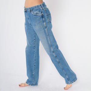Pu&ograve; includere: Un paio di jeans in denim blu chiaro con gamba dritta. I jeans hanno un design classico a cinque tasche e una chiusura con bottoni.