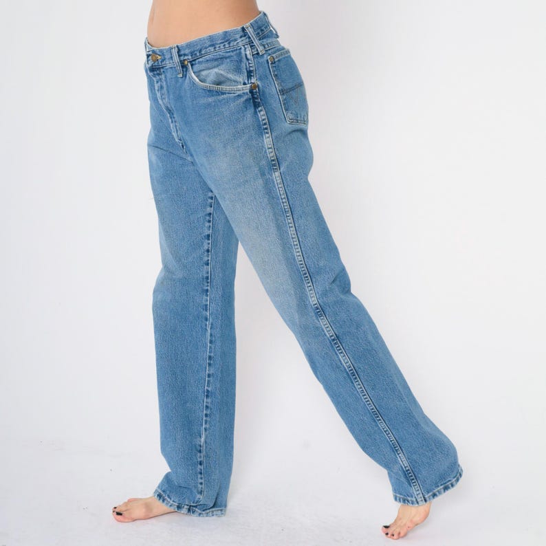 Pu&ograve; includere: Un paio di jeans in denim blu chiaro con gamba dritta. I jeans hanno un design classico a cinque tasche e una chiusura con bottoni.