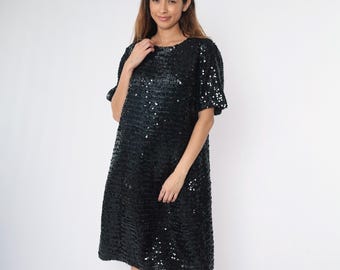 May include: A black sequin dress with short sleeves and a round neckline.