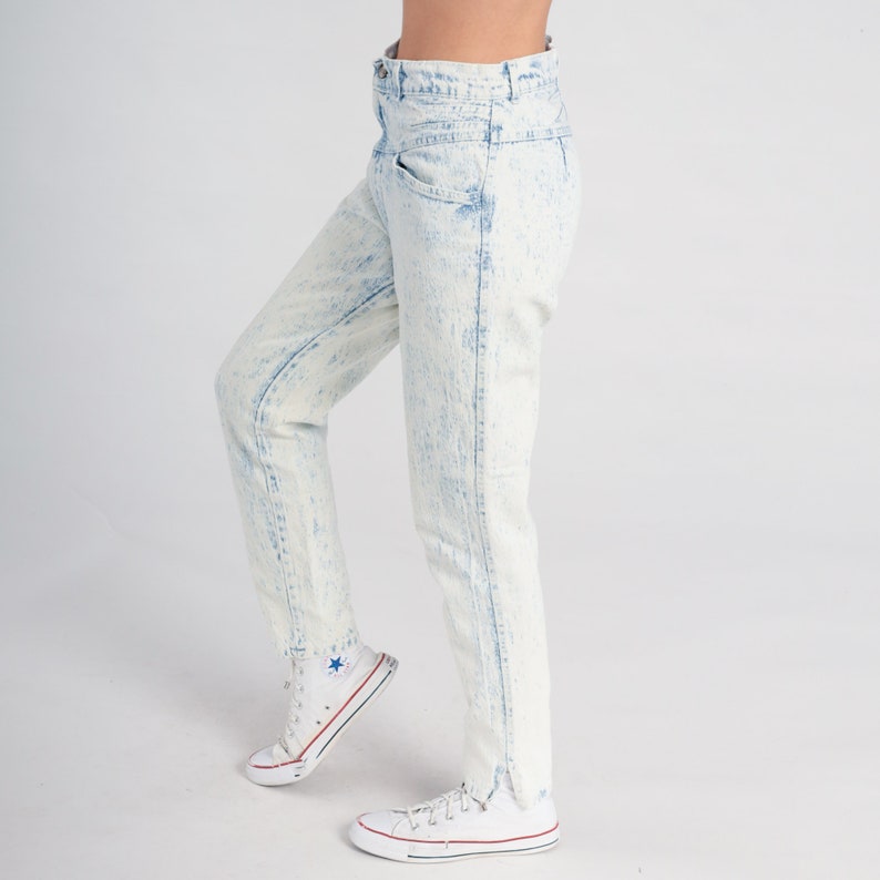 May include: Light blue acid wash denim jeans with a high waist and a straight leg fit.
