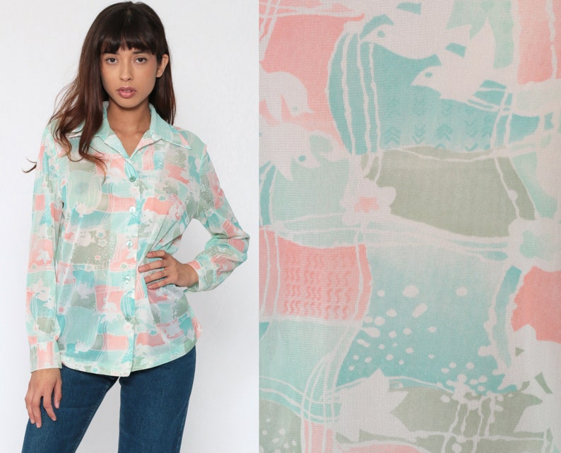 Puede incluir: Una camisa abotonada con un estampado abstracto en tonos pastel en azul claro, rosa y verde. La camisa de manga larga tiene cuello y est&aacute; hecha de una tela ligera y semitransparente.