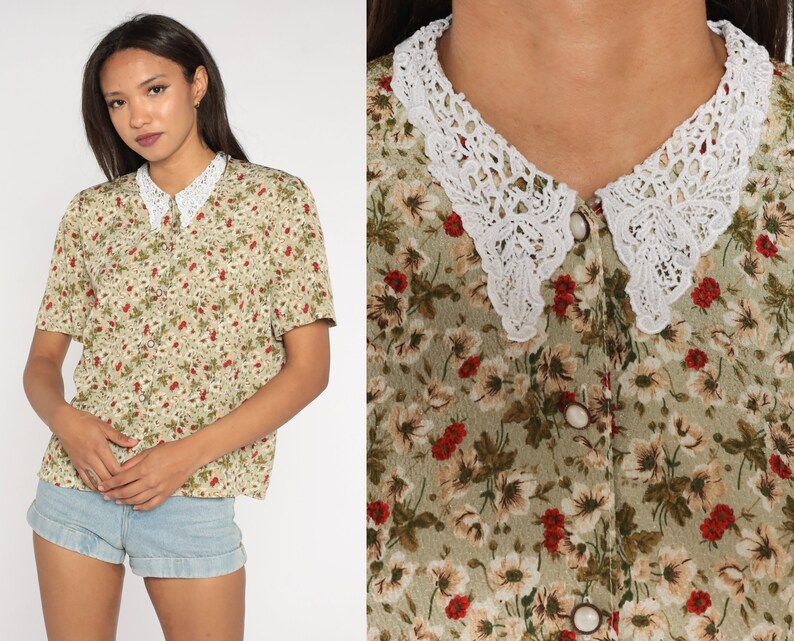 K&ouml;nnte beinhalten: Eine kurz&auml;rmlige Blumenbluse mit wei&szlig;em Spitzenkragen. Die Bluse hat eine Knopfleiste und ein Muster aus kleinen roten und wei&szlig;en Blumen auf hellgr&uuml;nem Hintergrund. Der Spitzenkragen ist ein auff&auml;lliges Detail.