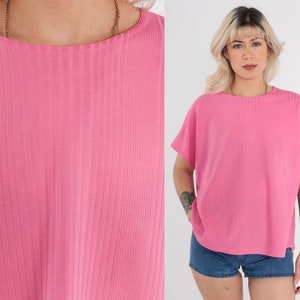 May include: A pink ribbed short-sleeved shirt with a round neckline.