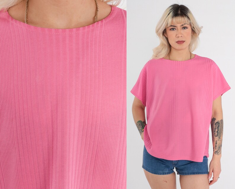 May include: A pink ribbed short-sleeved shirt with a round neckline.